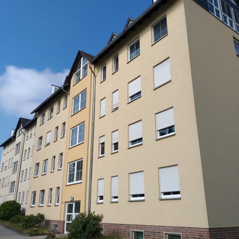 Wohnblock mit hellgelber Fassade, Längsansicht
