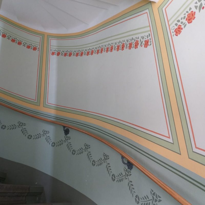 Historisches Treppenhaus mit Schablonenmalerei und Zierbändern