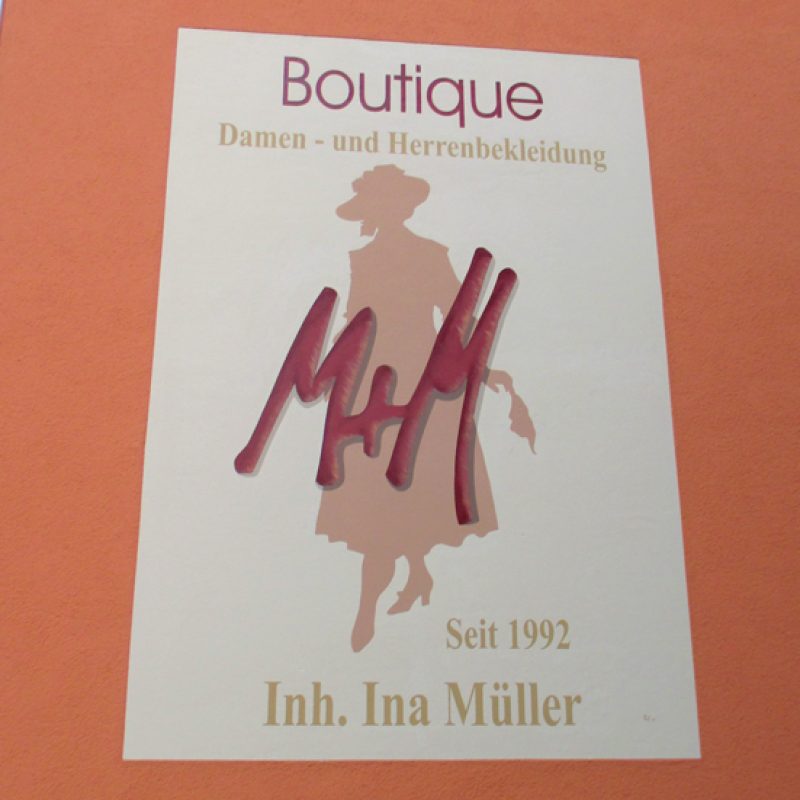 Fassadenschild der Boutique M+M für Damen- und Herrenbekleidung