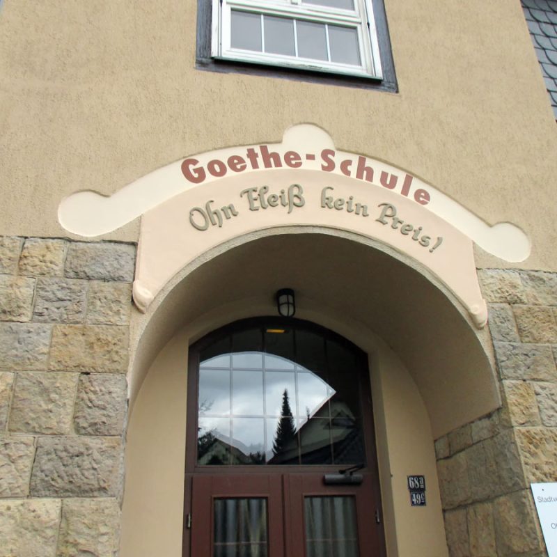 Eingang der Goethe-Schule Oelsnitz mit Schriftzug „Ohn Fleiß kein Preis“