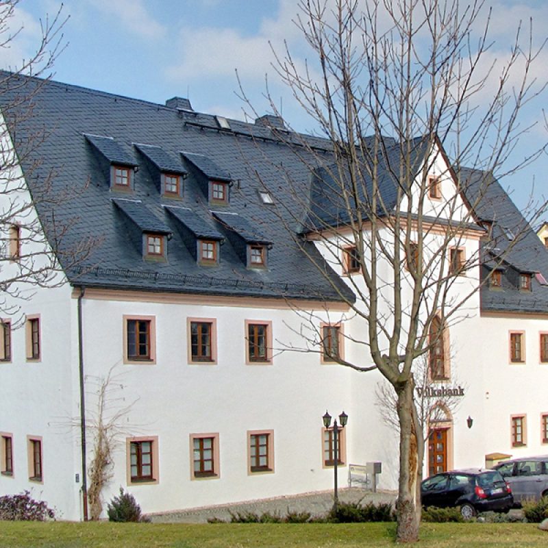 Historisches Gebäude mit weißer Fassade und Schieferdach
